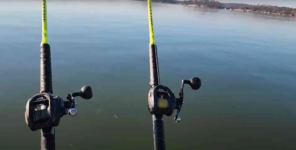 A pair of neon-green Hellcat rods rigged with sturdy baitcasting reels, pointed out over a glassy lake.